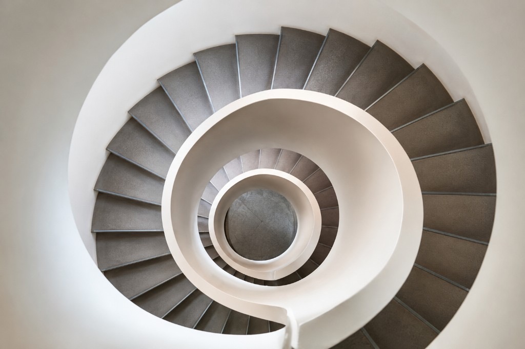Top-down view of a modern spiral staircase, suggesting recurring cycles and the turnover of receivables into cash