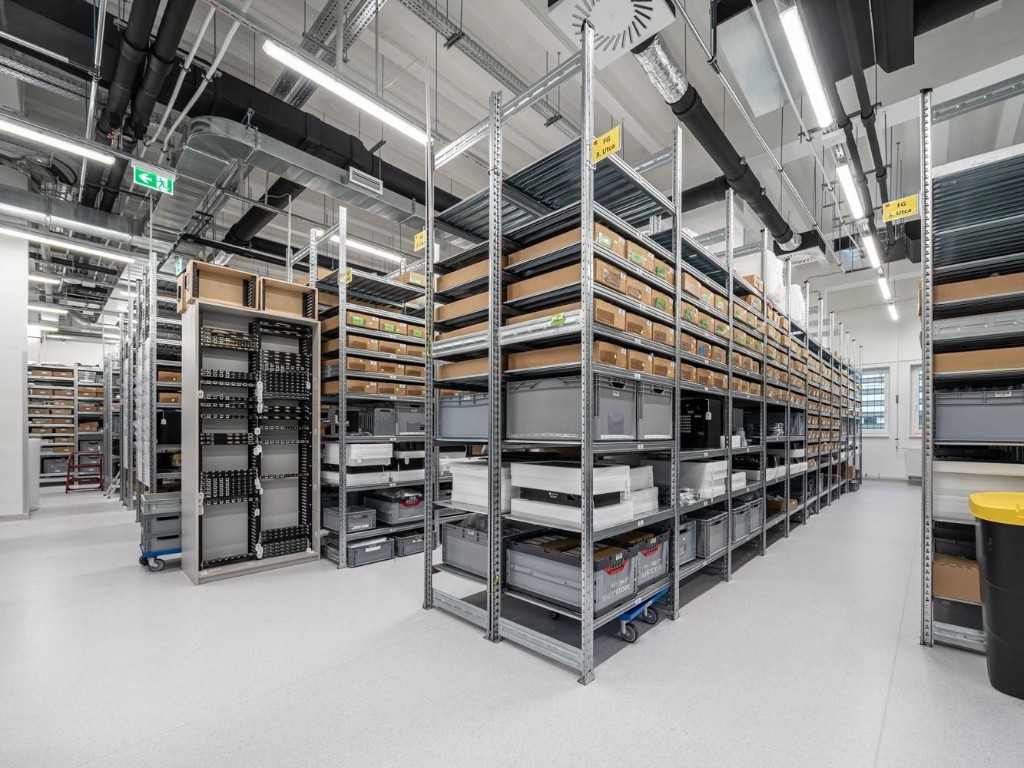 Modern warehouse with organized metal shelving and inventory, representing structured purchasing and supply chain management
