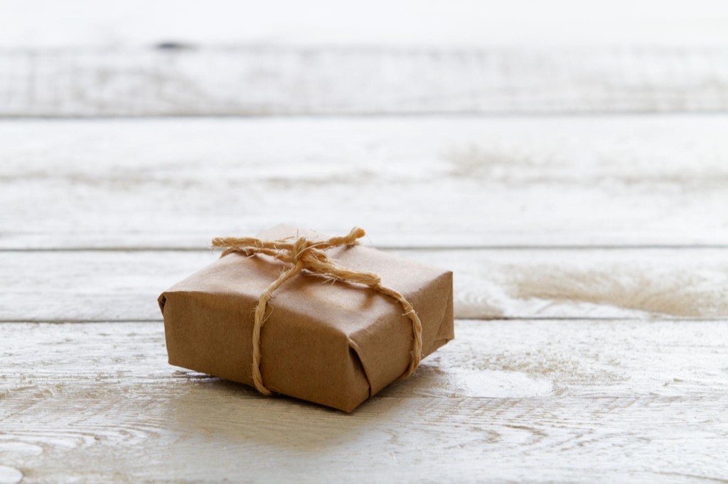 Minimal wrapped package on a clean surface, symbolizing a completed purchase